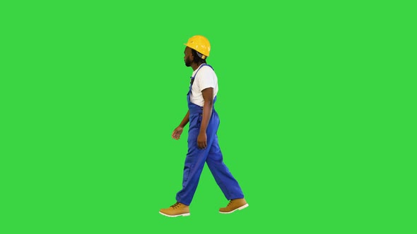 Handyman in a Helmet and Working Suit Walking on a Green Screen Chroma Key