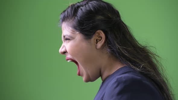 Young Overweight Beautiful Indian Businesswoman Against Green Background