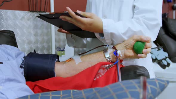Physician checking senior man donating blood 4k