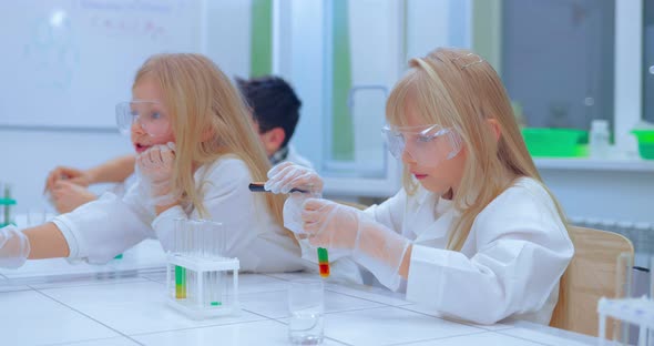 Group of Kids Making Experiments in Chemistry Class