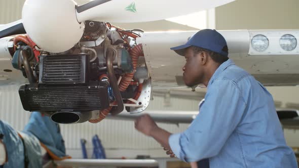 Black Aircraft Mechanic Working in Hangar