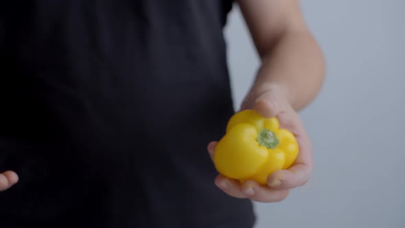 Chef Tosses Ripe Yellow Bell Pepper From Hand To Hand in Slow Motion, the Cook Juggles Vegetables