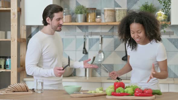 Young African Woman Arguing with Young Man in Kitchen