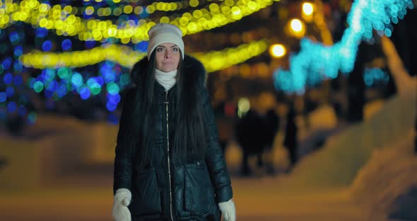 Beautiful and Happy Girl Walks Along the Night Alley