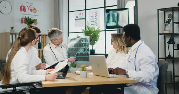 Medical Workers Discussing Results of Patient's X-ray Scan and Advicing About Further Treatment