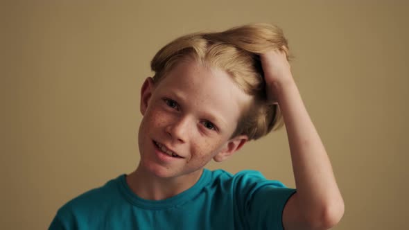 A close-up view of a happy little boy is posing