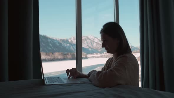 Tired Woman Working From Home Sitting in the Bedroom By the Window