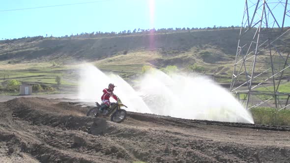 A young man riding a motocross dirt motorcycle.