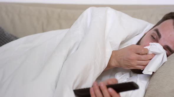 Man with Cough and Fever Watching TV