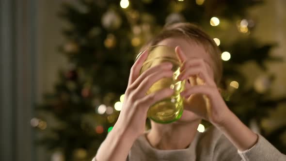 New Year. Funny Boy Sitting At The Table. He Drinks The Juice.