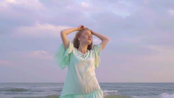 Portrait of Young Woman with Red Hair Standing at the Beach Close Up. Cute Girl Spends Time Near 