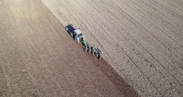 Tractor with a Plow Processes the Soil in Season