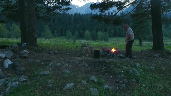 Man Burn Fire With Smoke Evening In Mountain Forest