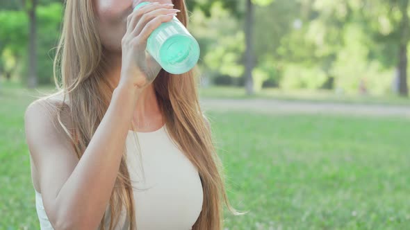 Healthy Fit Woman Drinking Water While Doing Yoga in the Park