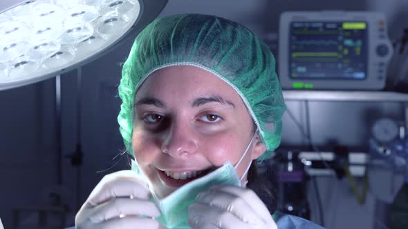 Adult Woman in Medical Mask and Hat Looking and Smiling at Camera Before Performing Surgery in