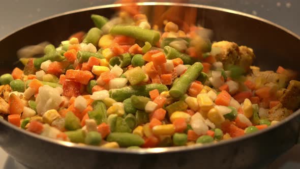 Frozen Vegetables are Poured Into a Pan with Fried Chicken