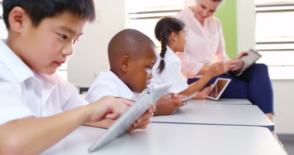 School kids and teacher using digital tablet in classroom