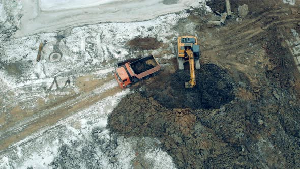 Excavating Machine Is Filling a Truck with Soil alt
