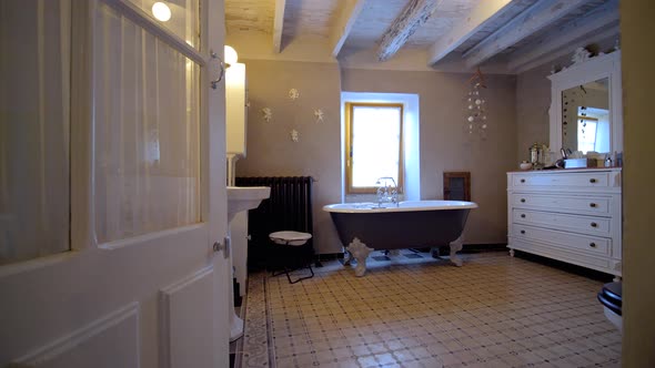 Entering vintage bathroom with free standing tub and wood roof beams, Dolly in shot