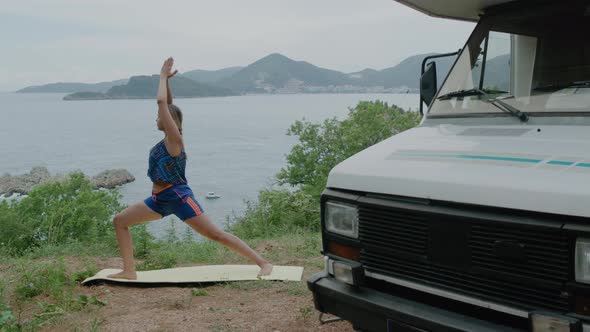 Young woman doing yoga pose against nature sea landscape in Montenegro