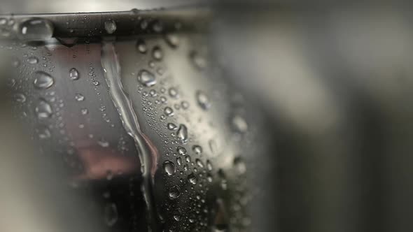 macro shot of a drop of water flowing down the aluminum can.