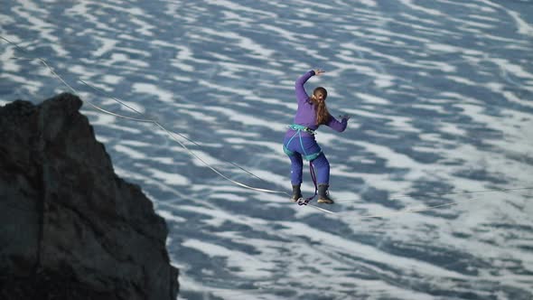 A Young Woman Is on the Slackline at High Altitude