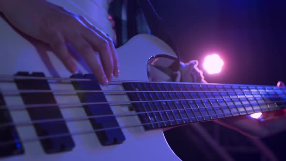 Female musician tuning her guitar before concert