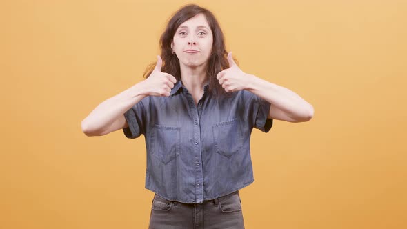 Young Woman Over Yellow Background Showing Thumbs Up Sign