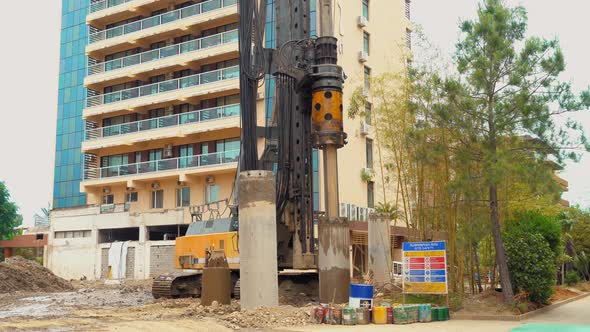 Earthmoving machine in construction site for drilling piles.