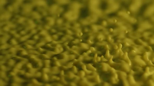 Macro Shot of Vibrating Spherical Drops of Yellow Milk