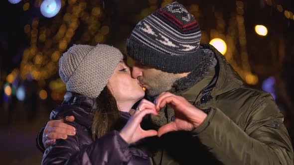 Happy Couple Making Heart Shape with Hands Gesturing Romantic Commitment Enjoying Loving