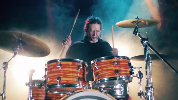 Professional Musician Is Playing the Drum Set with Water Splashes