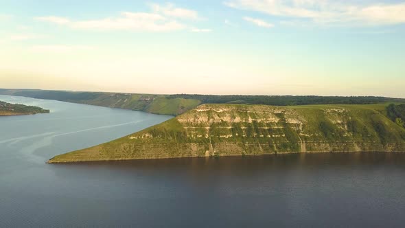 Aerial view of wide Dnister river and distant rocky hills in Bakota area, part of the National park