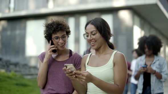 Happy Women Looking at Smartphone and Laughing