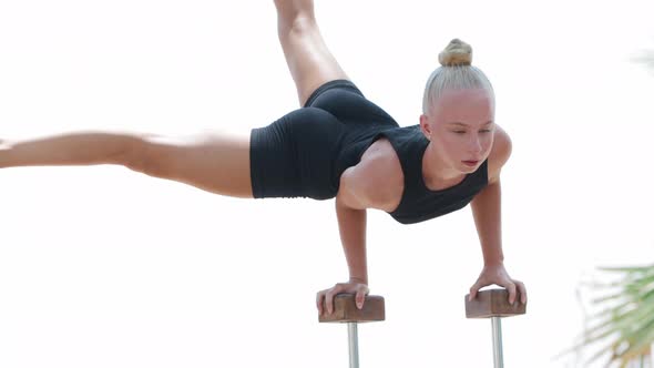 A Young Gymnast Balances on Her Strong Hands Resting on Wooden Stands