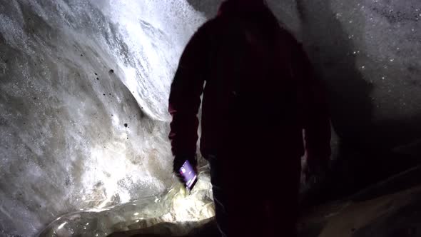 A Guy in an Ice Cave with a Lantern Light