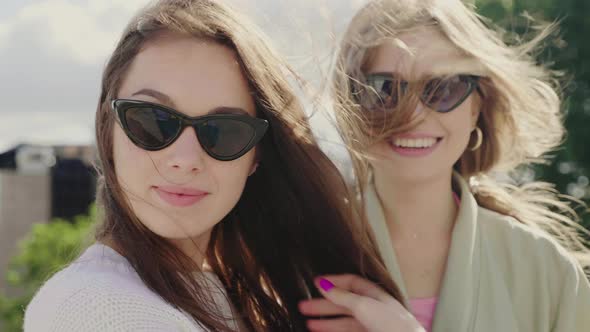 Two young beautiful women posing outdoors 