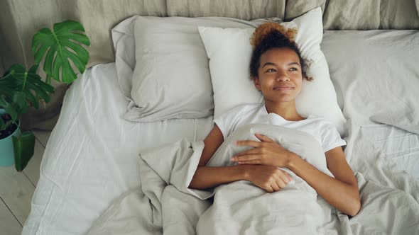 Happy Young Woman Is Lying in Bed Awake and Smiling Enjoying Carefree Life, Comfortable Bed