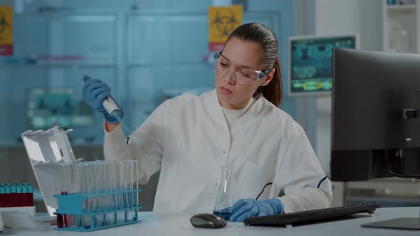 Scientist Working with Micro Pipette for Liquid in Beaker and Test Tube