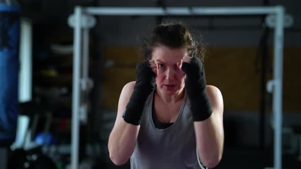 Female Boxer Practicing Punches and Looking at Camera