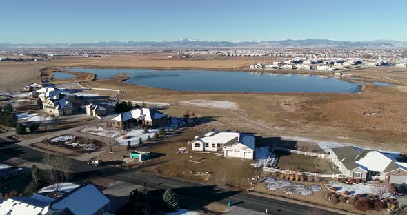 Mountain view and a lake in northern Colorado over a suburban neighborhood with construction.