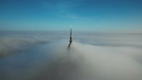 Drone Flying Around Ethereal Golden Abbey Steeple of Mont Saint Michel Castle in Normandy Under Epic
