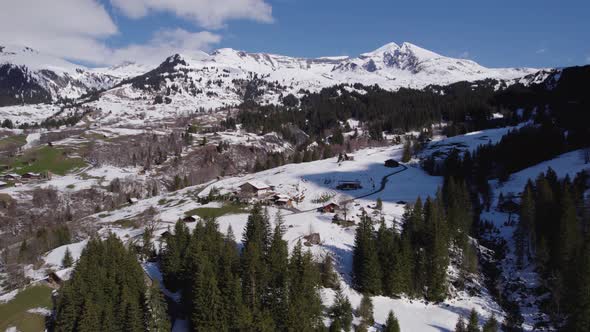 aerial drone footage of  late snow fall in spring in a dreamy mountain village in Swiss Alps