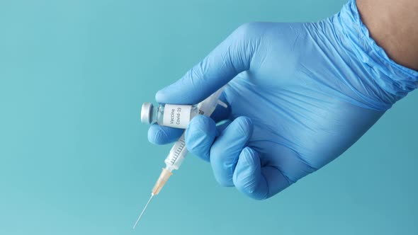 Hand in Latex Gloves Holding Glass Ampoule Vaccine with Copy Space