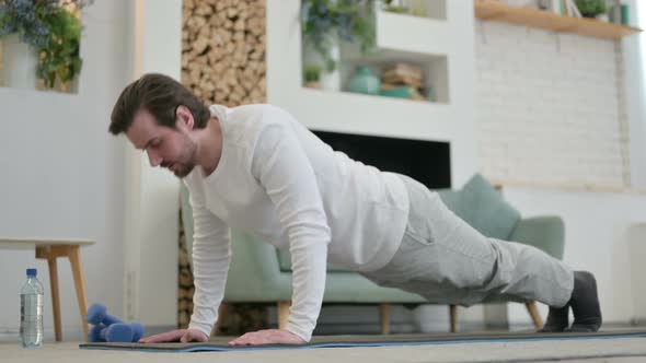 Tired Young Man Doing Pushups on Yoga Mat at Home