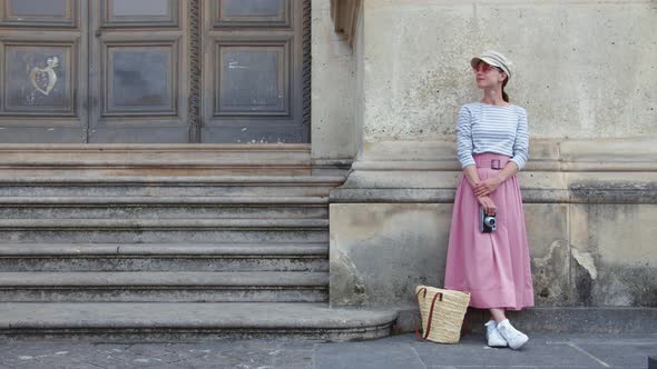 Young girl with a camera at the old stairs. Paris