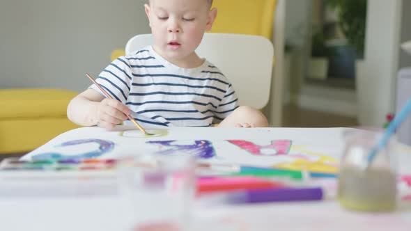 Preparing First Day at School Concept Child Kid Boy Drawing ABC Letters on Paper