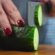 Women cuts a cucumber with a knife - VideoHive Item for Sale