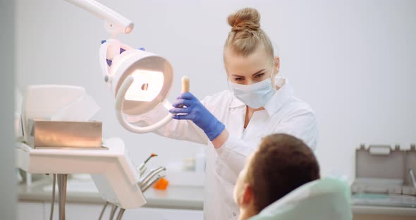 Female Dentist Treats Patient at Dental Clinic