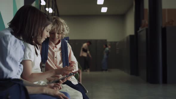 Joyful Classmates Watching Tablet in Hallway